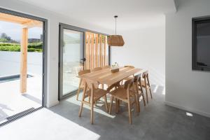 uma sala de jantar com uma mesa de madeira e cadeiras em Figueiras House Pópulo Beach em Ponta Delgada