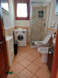 bagno con doccia, servizi igienici e lavatrice. di Sweet Home a Santa Teresa di Gallura