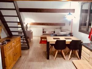 a living room with a table and chairs and a staircase at Appartement Duplex Forclaz in Chamonix +26 photos