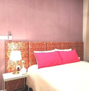 a bed with a red headboard next to a table with a lamp at Vista Residence Genting Highland in Genting Highlands