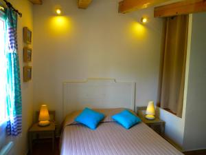 a bedroom with a bed with two blue pillows at A ChiOsella in Corbara