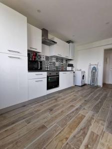 a large kitchen with white appliances and wooden floors at Saint-Pierre - 3 chambres - WIFI - Spacieux - Neuf in Brest
