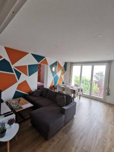 a living room with a couch and a geometric wall at Saint-Pierre - 3 chambres - WIFI - Spacieux - Neuf in Brest