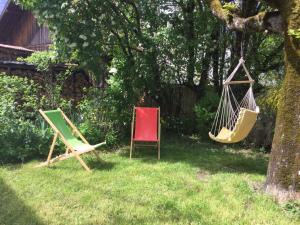 2 sillas y una hamaca en un patio en Au Refuge de Blanche en Verchères