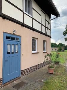 a house with a blue door on the side of it at Spreewaldhaus Melcher in Leipe