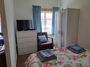 a bedroom with a bed and a tv and a chair at Sharon's Studio Blue in Maastricht