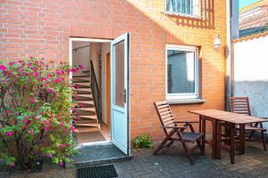 a patio with a table and chairs next to a brick building at Seestern in Warnemünde