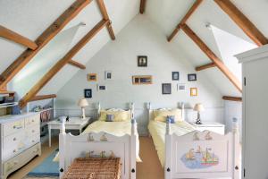 a bedroom with two beds in a attic at Demeure des Hauts Champs - à 800m de la plage de Pen Guen in Saint-Cast-le-Guildo