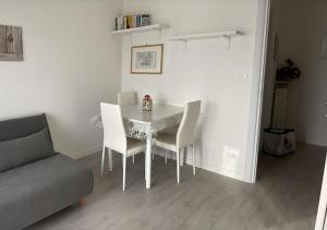 a dining room table with white chairs and a couch at BnB Arianna's home in Turin +6 photos