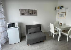 a living room with a table and a chair and a microwave at BnB Arianna's home in Turin