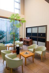 una sala de espera con sillas y mesas y una maceta en Okano Hotel, en Sendai