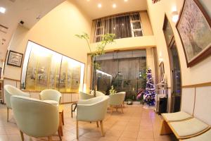 een wachtkamer met witte stoelen en planten bij Okano Hotel in Sendai