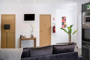 a living room with a couch and a tv at Capelas Pdl Apartment in Capelas