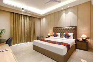 a bedroom with a large bed and a desk at FabHotel Infinity Stay II in Gurgaon