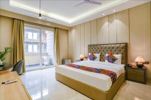 a bedroom with a large bed and a large window at FabHotel Infinity Stay II in Gurgaon
