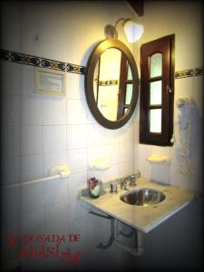 y baño con lavabo y espejo. en La Posada de Akasha en Villa General Belgrano