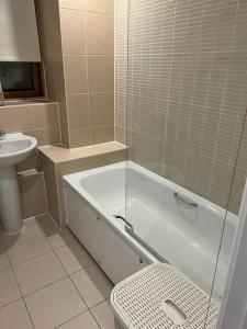 a bathroom with a tub and a toilet and a sink at Comfy One bedroom Apartment in London