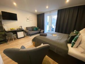 a bedroom with a bed and a living room at Vila LEMAR wellness & spa in Huncovce