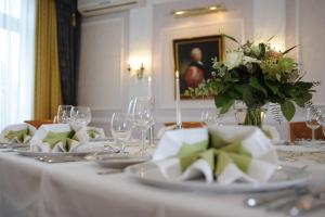 a table with white dishes and a vase of flowers at Parkhotel Altmühltal in Gunzenhausen