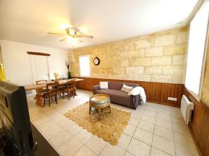 a living room with a couch and a table at Maison de vacances Gite le Margot in Cantenac