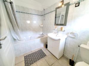 bagno con lavandino, vasca e servizi igienici di Maison de vacances Gite le Margot a Cantenac