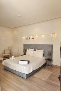 una camera con un grande letto e una sedia di Riad Tsar Mimoun a Marrakech