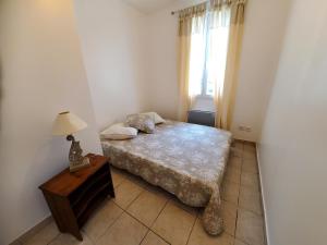 a bedroom with a bed and a table with a lamp at Maison de vacances Gite le Margot in Cantenac