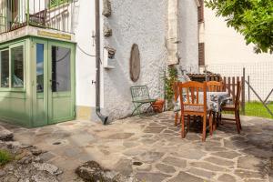 a patio with a table and chairs in front of a house at Destinazione Paradiso in Grondola