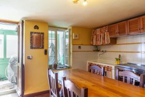 a kitchen with a large wooden table and chairs at Destinazione Paradiso in Grondola