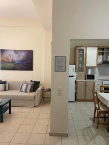 ein Wohnzimmer mit einem Sofa und einer Küche in der Unterkunft SISSOU WELCOMe PLACe in Kalamata
