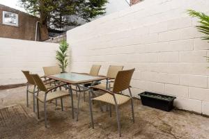 a table and chairs sitting next to a brick wall at Fairfield House Refurbed stylish house for contractors & Tourists in Liverpool