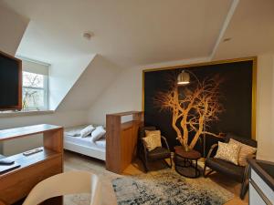una habitación con una cama y un árbol en ella en ArtRoom Boarding Apartment, en Bissendorf
