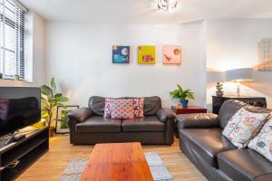 Sala de estar con 2 sofás de cuero y mesa de centro en Spitalfields one bedroom apartment, en Londres