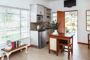 a kitchen with a table and a desk and a table and chairs at Naftali Guest Farm in Kanoneiland