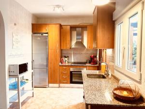 a kitchen with wooden cabinets and stainless steel appliances at Casa Buena Vista with private pool in Mazarrón