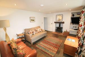 a living room with a couch and a table at Red Squirrel Cottage, Hutton in Penruddock