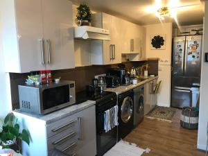 a kitchen with a microwave and a washer and dryer at Stoddart House in Newcastle upon Tyne