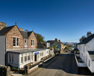 an empty street in a small town with houses at Plockton Inn in Plockton
