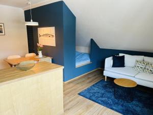 シャルボイツにあるBaltic Nr. 22の白いソファと青い壁のリビングルーム