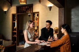 a group of three people standing around a table at Nham Village Resort in Ninh Binh
