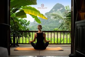 een vrouw in een yoga pose in een deuropening bij Nham Village Resort in Ninh Binh