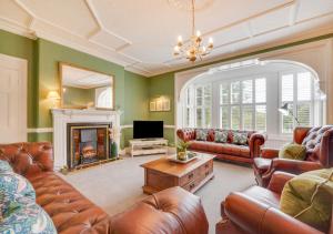 a living room with leather furniture and a fireplace at Church Beck House in Scalby
