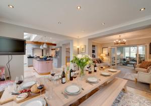 a dining room and living room with a table with wine bottles at Church Beck Retreat in Scalby