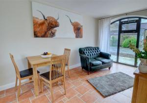 a living room with a table and a chair at Clematis Cottage in Gilling East +4 photos