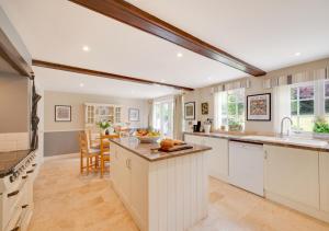 a kitchen with white cabinets and a dining room at Church Beck House in Scalby