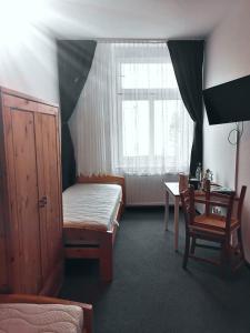 a bedroom with a bed and a desk and a window at Pension zum Hirsch in Hattersheim