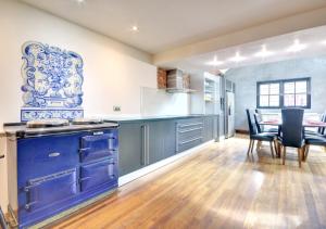 una cucina con armadi blu, tavolo e sedie di Cherry Tree House a Helmsley
