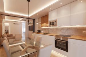 a kitchen with white cabinets and a table and chairs at Silva 20 in Madrid