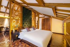 ein Schlafzimmer mit einem großen weißen Bett in einem Zimmer in der Unterkunft SecGarden Boutique Hotel in Zhangjiajie