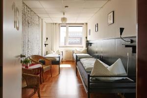 a room with several beds and a table and chairs at Sleep Station Hostel in Münster